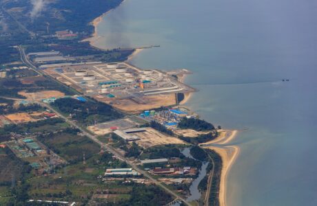 Aerial view of the Sabah Oil and Gas Terminal at Kimanis with storage tanks and gas flare on the coastline.
