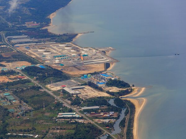 Aerial view of the Sabah Oil and Gas Terminal at Kimanis with storage tanks and gas flare on the coastline.